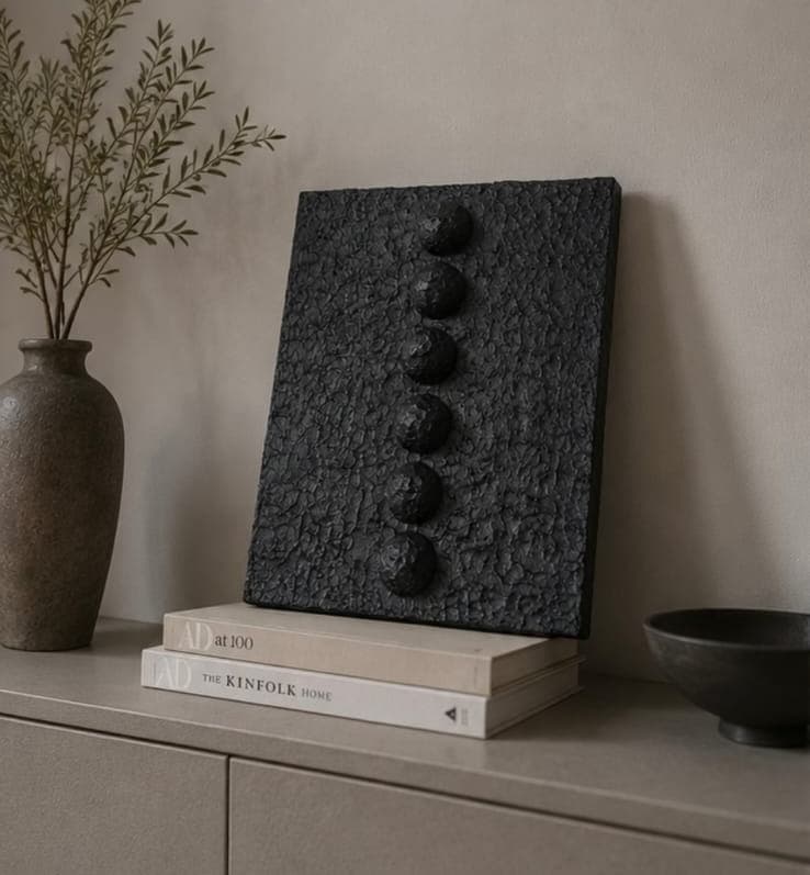 Tasbih: black textured relief with six raised beads, styled on a console
