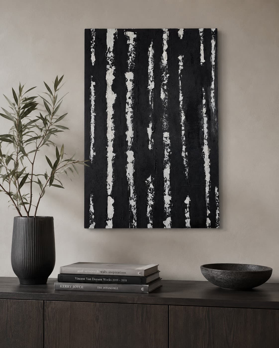 Baran: a large black canvas scraped with falling white plaster marks, hung above a dark console